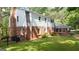 A large backyard featuring a brick house, green grass, and a black fence at 2179 Mountclaire Ct, Stone Mountain, GA 30087