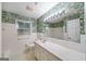 A bathroom featuring a large mirror, vanity, and jungle themed wallpaper at 2179 Mountclaire Ct, Stone Mountain, GA 30087