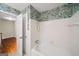 This bathroom features jungle-themed wallpaper, a shower and a bathtub at 2179 Mountclaire Ct, Stone Mountain, GA 30087