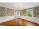 Charming dining room features hardwood floors, floral wallpaper, and a classic chandelier at 2179 Mountclaire Ct, Stone Mountain, GA 30087