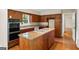 Traditional kitchen features wood cabinets, an island cooktop, and granite countertops at 2179 Mountclaire Ct, Stone Mountain, GA 30087