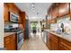 Galley kitchen with granite counters, stainless steel appliances, and warm wood cabinets at 345 Wynbrook Dr, Mcdonough, GA 30253