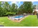 Backyard pool featuring a lounging area, a fenced perimeter, and lush trees at 345 Wynbrook Dr, Mcdonough, GA 30253
