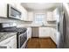 This well-lit kitchen has stainless steel appliances, sleek granite countertops, and wood flooring at 503 Countryside Se Pl, Smyrna, GA 30080