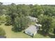 Aerial view of property showcasing house and detached garage surrounded by mature trees and green lawns at 306 Tyrone Rd, Fayetteville, GA 30214