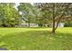 Large green backyard surrounded by mature trees and landscaping, creating a serene and private outdoor space at 306 Tyrone Rd, Fayetteville, GA 30214