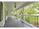 A side view of a covered front porch with black railings and white columns overlooking a tree filled yard at 306 Tyrone Rd, Fayetteville, GA 30214
