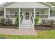 Inviting front porch with elegant columns, dark railings, landscaping and a stained front door at 306 Tyrone Rd, Fayetteville, GA 30214