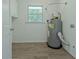 Functional laundry room includes storage, natural light, and updated water heater at 306 Tyrone Rd, Fayetteville, GA 30214