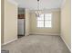 Bright dining area with an elegant chandelier, neutral carpeting, and a view to the kitchen for effortless entertaining at 545 Grand Teton Cir, Fayetteville, GA 30215
