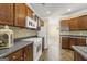 Functional kitchen with white appliances, wooden cabinetry, and tile backsplash at 545 Grand Teton Cir, Fayetteville, GA 30215