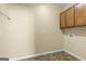 Functional laundry room featuring durable vinyl flooring, overhead cabinets, and essential appliance connections for added convenience at 545 Grand Teton Cir, Fayetteville, GA 30215