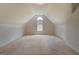An attic room with carpet, sloped ceiling, and window for natural light at 235 Rustic Mill Ln, Fayetteville, GA 30214