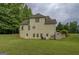 Rear of the home displaying a spacious backyard, walkout basement, and wooded border at 235 Rustic Mill Ln, Fayetteville, GA 30214