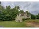 The back of the home showing a sprawling yard, gentle slope, and wooded backdrop at 235 Rustic Mill Ln, Fayetteville, GA 30214