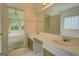 Bathroom featuring a double sink vanity, large mirror, and view into an adjacent room at 235 Rustic Mill Ln, Fayetteville, GA 30214