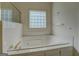 Close-up of a tiled bathtub with glass block window at 235 Rustic Mill Ln, Fayetteville, GA 30214
