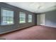 Spacious bedroom featuring three windows, neutral walls, ceiling fan, and neutral color carpet at 235 Rustic Mill Ln, Fayetteville, GA 30214