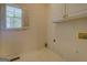 Functional laundry room with a window for natural light and storage cabinets at 235 Rustic Mill Ln, Fayetteville, GA 30214