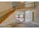 Bright living room featuring a staircase overlooking carpet and a view into adjacent living spaces at 235 Rustic Mill Ln, Fayetteville, GA 30214