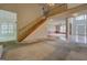 Open living room with wood staircase and railings overlooking carpeted floors at 235 Rustic Mill Ln, Fayetteville, GA 30214