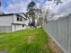 A large fenced backyard with a lush lawn, a patio deck, and mature trees surrounding the property at 295 Lamden Ct, Lawrenceville, GA 30046