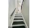 View of the staircase featuring dark wood steps, white risers, and a gray handrail at 295 Lamden Ct, Lawrenceville, GA 30046