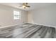 This spacious bedroom features wood-look floors, a ceiling fan, fresh paint and a large window at 770 Four Winds Ln, Jonesboro, GA 30238
