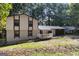 View of a two-story house with neutral siding, attached garage, covered porch, and mature trees at 770 Four Winds Ln, Jonesboro, GA 30238