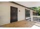 View of a front porch with a security door, wood decking, and neutral siding at 770 Four Winds Ln, Jonesboro, GA 30238