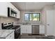 This bright kitchen features stainless appliances, white cabinets, granite countertops, and wood-look floors at 770 Four Winds Ln, Jonesboro, GA 30238