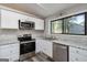 Bright kitchen features stainless appliances, white cabinets, and large window with a view at 770 Four Winds Ln, Jonesboro, GA 30238