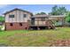 Large backyard with a wooden deck, mature trees, and a well-maintained lawn for outdoor enjoyment at 8310 Meridian Dr, Riverdale, GA 30274