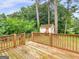 A wooden deck in a lush, green backyard with a shed and plenty of trees provides a private outdoor space at 8310 Meridian Dr, Riverdale, GA 30274