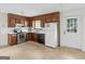 Kitchen features wood cabinetry, white appliances, and tile flooring at 8310 Meridian Dr, Riverdale, GA 30274