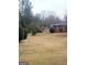 Wide view of the expansive backyard with mature trees and a storage shed at 500 Circle Dr, Fayetteville, GA 30214