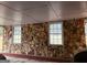 Covered patio with exposed stone wall, windows, and brick trim at 500 Circle Dr, Fayetteville, GA 30214
