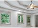 Bedroom featuring tray ceilings, a ceiling fan, and large windows offering backyard views at 187 Vanira Se Ave, Atlanta, GA 30315