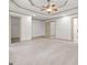 Large carpeted bedroom with a tray ceiling, ceiling fan, and multiple doorways at 187 Vanira Se Ave, Atlanta, GA 30315