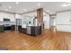 Open kitchen featuring white cabinets, stainless appliances, island with seating, and hardwood floors at 187 Vanira Se Ave, Atlanta, GA 30315