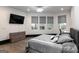 Modern bedroom featuring three windows, light hardwood floors, and a comfortable bed at 2401 Ne Greenglade Rd, Atlanta, GA 30345