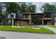 Beautiful modern home with dark and light wood tones, garage doors, and green lawn at 2401 Ne Greenglade Rd, Atlanta, GA 30345
