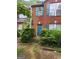 Traditional red brick townhouse featuring a teal front door, shutters, and well kept shrubbery at 2756 Norfair Loop, Lithonia, GA 30038