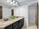 Well-lit bathroom features granite countertops, black cabinets, and a shower with a tub at 5825 Trailwood Ct, Suwanee, GA 30024
