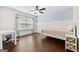 Cozy bedroom features hardwood floors, a ceiling fan, and a large window at 5825 Trailwood Ct, Suwanee, GA 30024