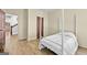 Comfortable bedroom featuring a white poster bed, wood floors, and a glimpse into the home's hallway at 5825 Trailwood Ct, Suwanee, GA 30024