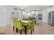 Dining room with a glass table, green chairs, and a view into the kitchen at 5825 Trailwood Ct, Suwanee, GA 30024