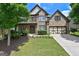 Stately brick home with manicured lawn, mature landscaping, and a two-car garage at 5825 Trailwood Ct, Suwanee, GA 30024