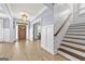 Bright foyer with staircase, chandelier, wainscoting, and hardwood floors at 5825 Trailwood Ct, Suwanee, GA 30024