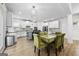 Bright kitchen with white cabinets, a center island, stainless steel appliances, and a dining area with an elegant chandelier at 5825 Trailwood Ct, Suwanee, GA 30024